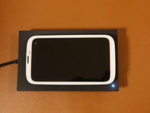 BALMUDA Phone 本体をワイヤレス充電器に乗せて重電しているところ